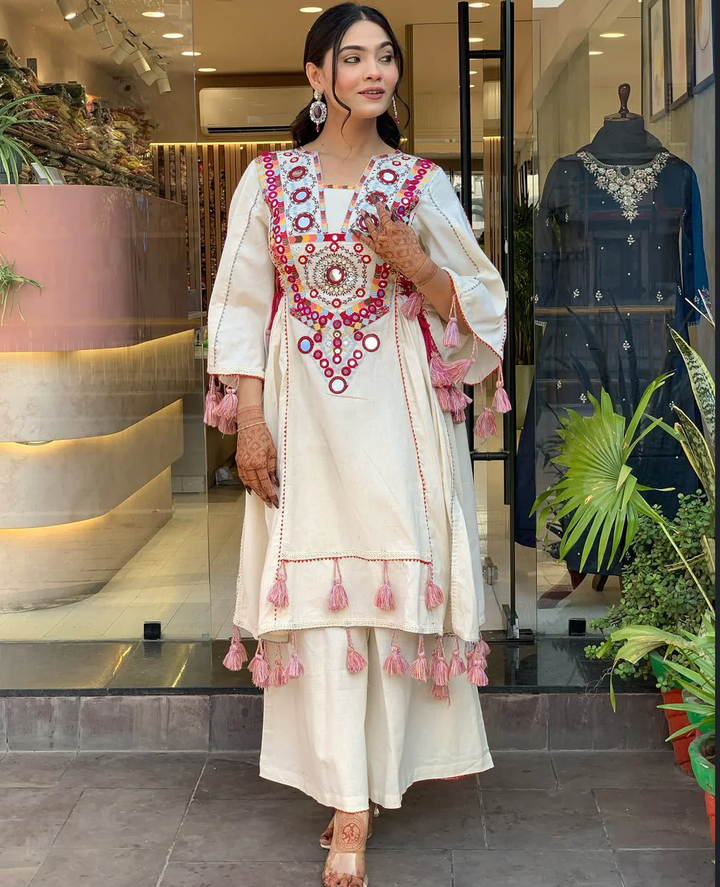 Hand-Embroidered Designer Peplum & Bell Bottom Set with Real Mirror Work Cream Kurta Set with Pink Tassels – Ethnic Festive Wear for Women