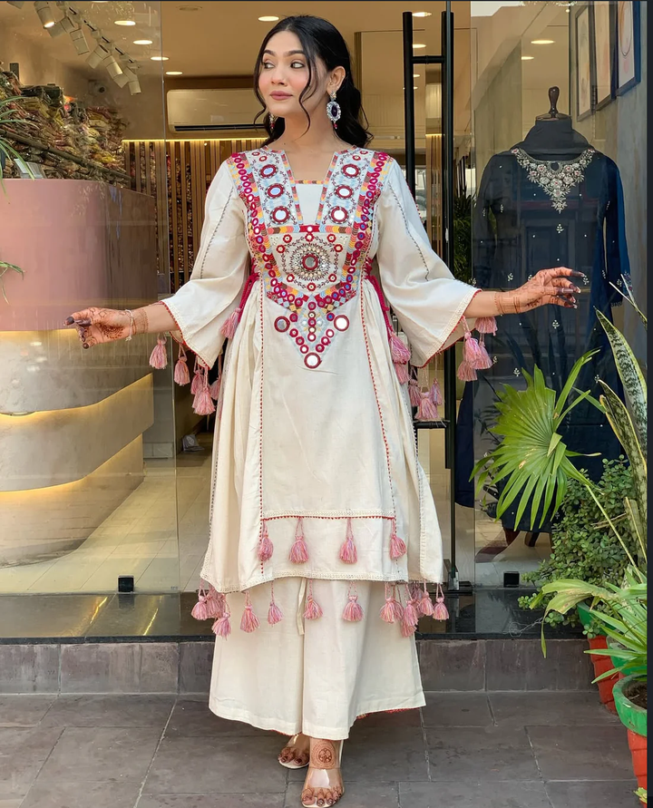 Hand-Embroidered Designer Peplum & Bell Bottom Set with Real Mirror Work Cream Kurta Set with Pink Tassels – Ethnic Festive Wear for Women