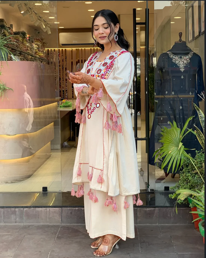 Hand-Embroidered Designer Peplum & Bell Bottom Set with Real Mirror Work Cream Kurta Set with Pink Tassels – Ethnic Festive Wear for Women