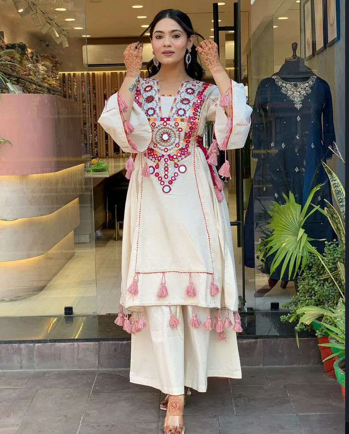 Hand-Embroidered Designer Peplum & Bell Bottom Set with Real Mirror Work Cream Kurta Set with Pink Tassels – Ethnic Festive Wear for Women