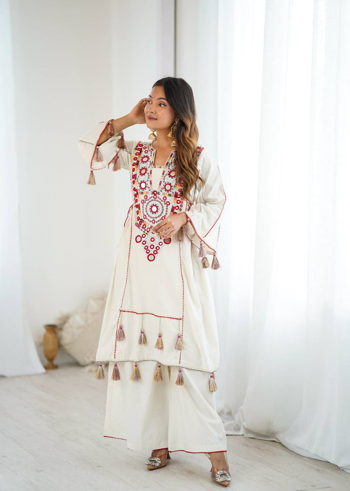 Hand-Embroidered Designer Peplum & Bell Bottom Set with Real Mirror Work Cream Kurta Set with Pink Tassels – Ethnic Festive Wear for Women